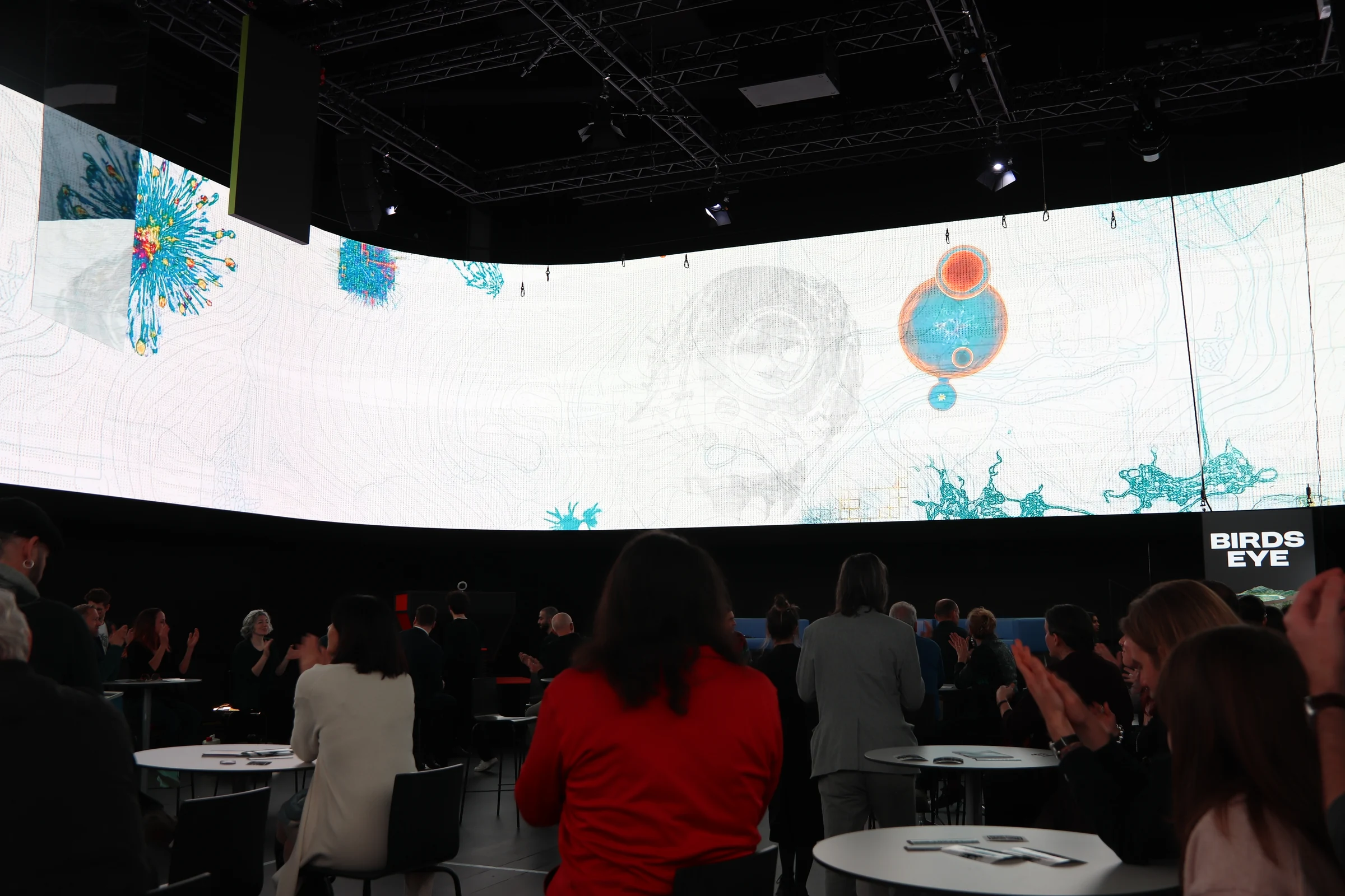 Besucherinnen und Besucher unter einer hellen, farbigen 360-Grad-Projektion im Haus der Digitalisierung